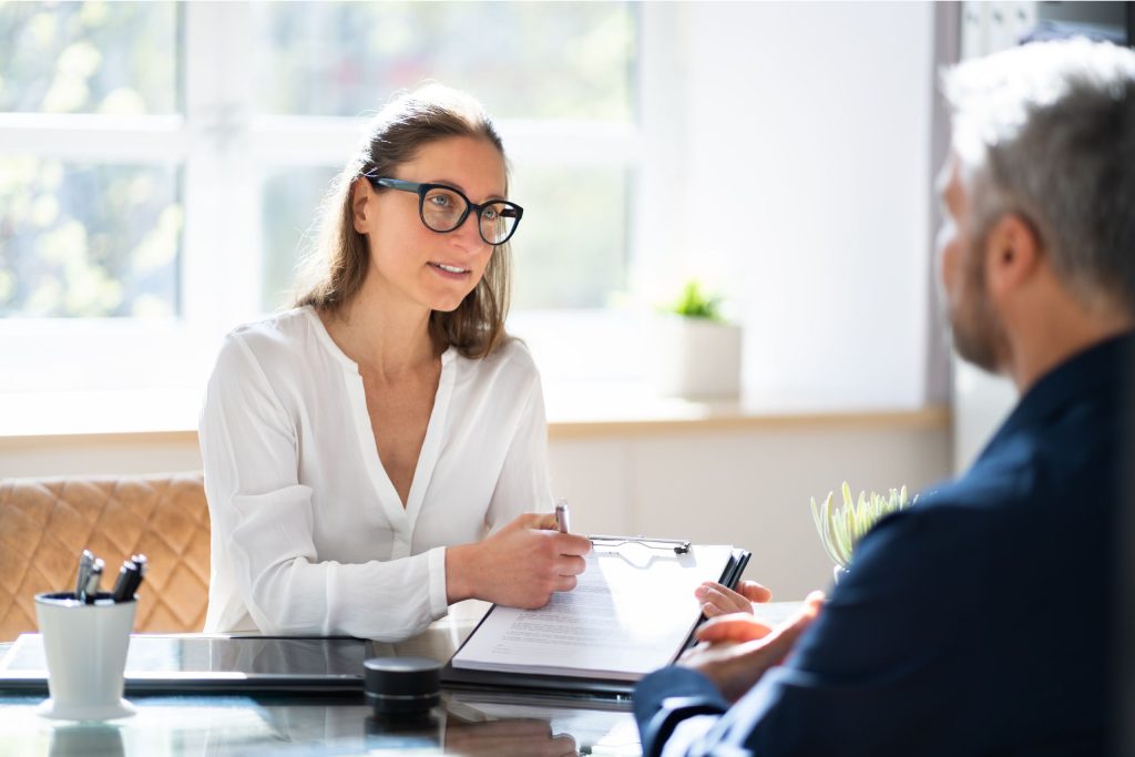 plan-for-growth-scaled financial consultant shows a clipboard with a contract agreement to a client